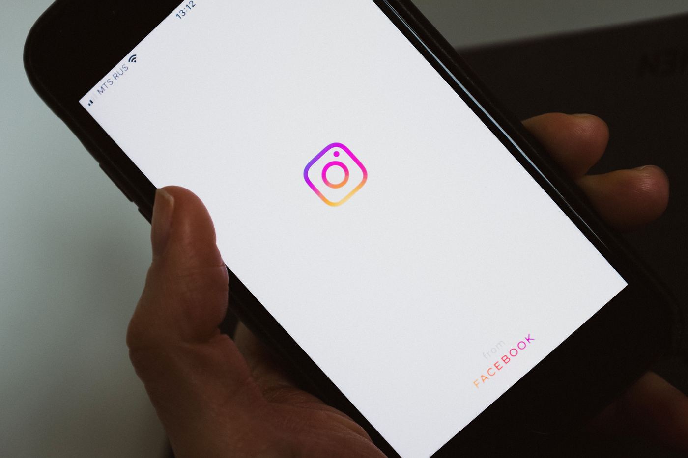 Mano con móvil mostrando una aplicación de redes sociales